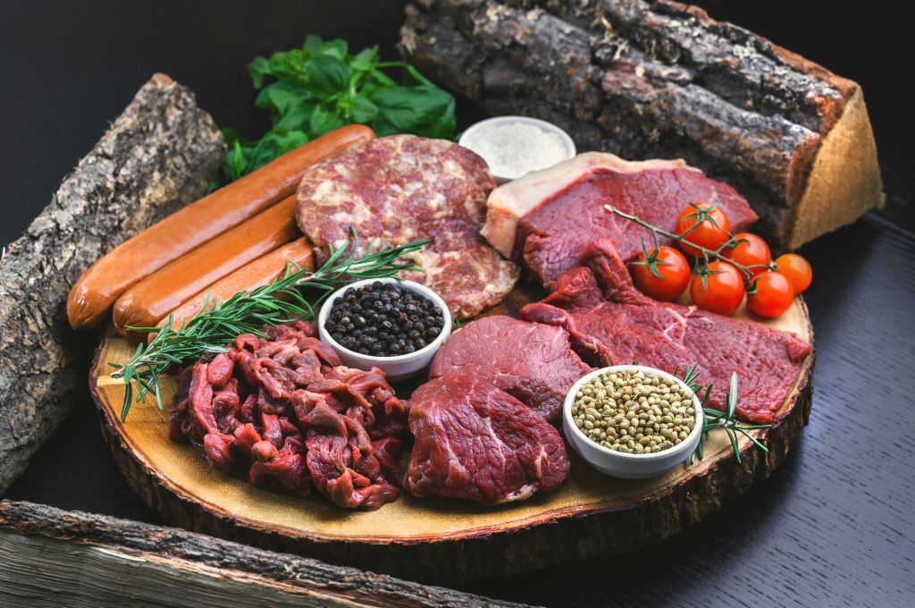 hormone free meat assorted organic meat displayed on wood cutting board