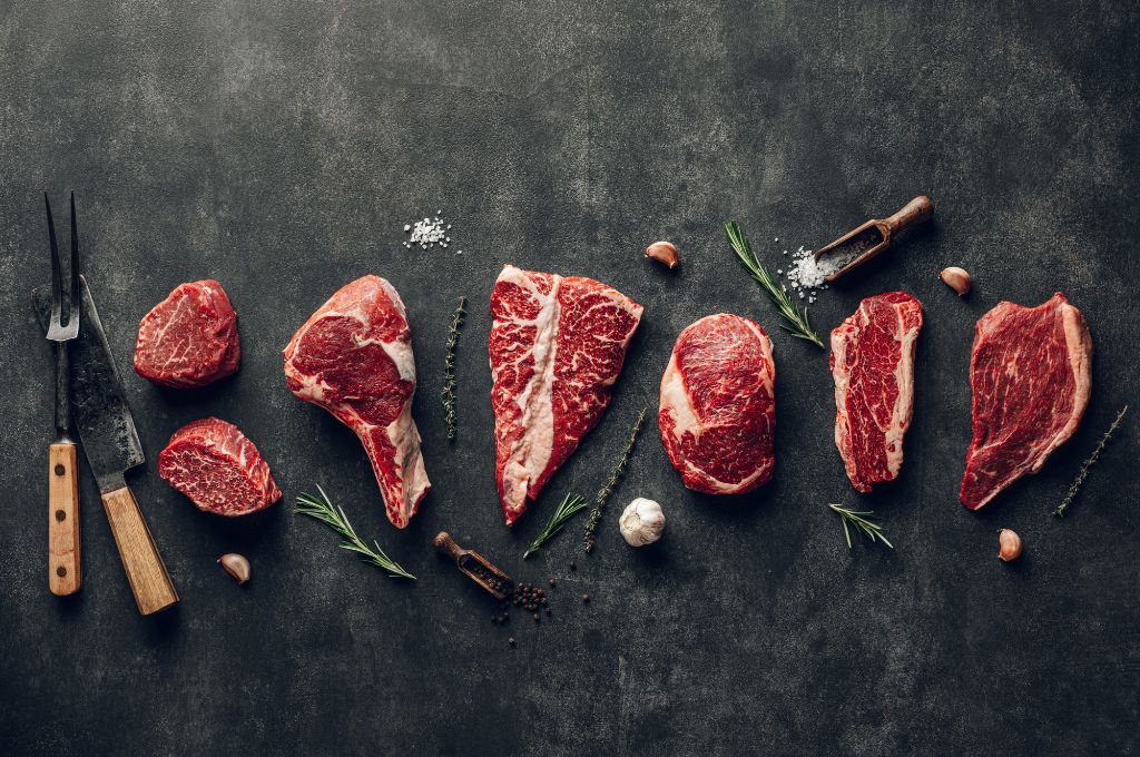 local meat delivery box options displayed flat with knives and herbs surrounding them